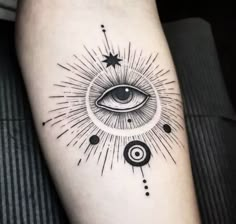 an all seeing eye tattoo on the left arm with circles and stars around it in black ink