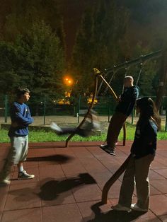 three people are playing in the park at night