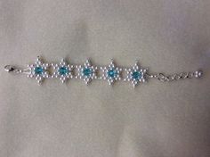 the bracelet is adorned with pearls and blue stones