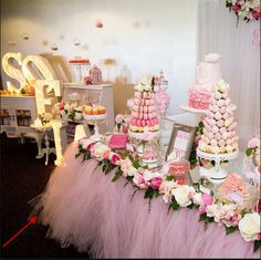 a table topped with lots of cakes and cupcakes