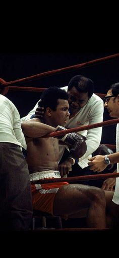 two men in the ring with one holding his arm around another man's shoulder