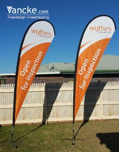 two orange and white feathered banners in front of a wooden fence with the words wythres on them