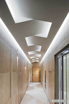 an empty hallway is lit up with recessed lighting and white carpeting on both sides