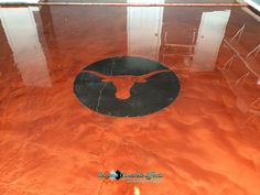 an orange floor with a black bull head painted on the bottom and red paint around it