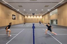 several people playing tennis on an indoor court