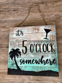 a wooden sign that says it's 5 o clock somewhere with a palm tree