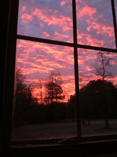 the sky is pink and purple as seen through a window