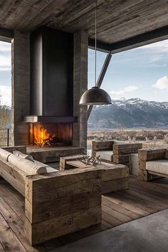 a living room filled with furniture and a fire place in the middle of a wooden floor