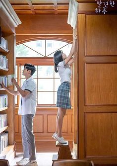 two people standing in front of a bookshelf