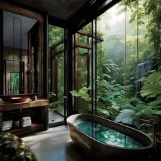 a bath tub sitting in the middle of a bathroom next to a lush green forest