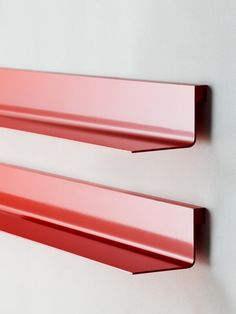 two red metal shelfs mounted to the wall