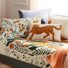 a bed covered in pillows with a tiger on it