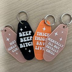 three key chains with sayings on them sitting next to each other in front of a table