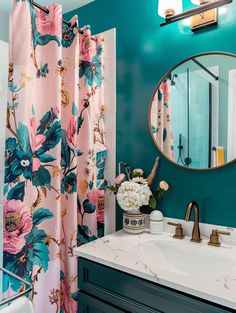 a bathroom with blue walls and floral shower curtain