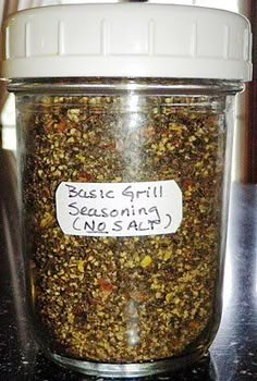 a glass jar filled with seasoning sitting on top of a counter