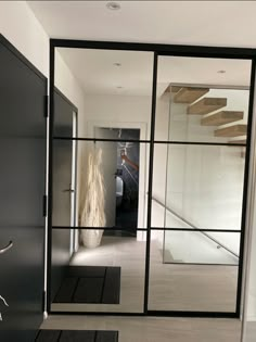 an entry way with glass doors and stairs leading up to the second floor in this modern home