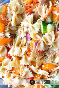 pasta salad with carrots, cucumbers, and onions in a glass bowl