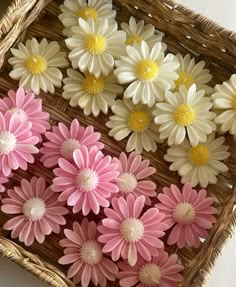 some pink and white flowers are in a basket