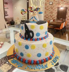 a birthday cake decorated with scissors and sprinkles