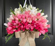 a bouquet of pink and white tulips in front of a door