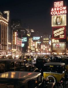 a busy city street filled with lots of traffic and tall buildings lit up at night