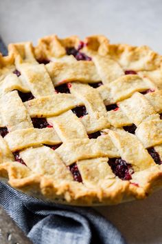 a close up of a pie on a table with a blue napkin and fork next to it