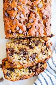 two slices of chocolate chip banana bread on top of a blue and white striped towel