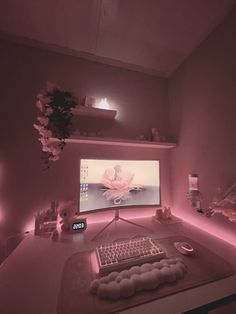 a desk with a keyboard, mouse and monitor in the middle of it is lit up by pink lighting