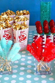 popcorn and strawberries are sitting in vases on a table