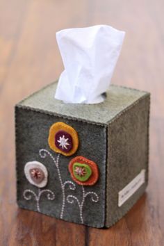 a tissue dispenser sitting on top of a wooden table