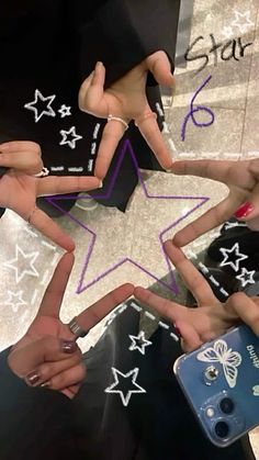 several people are holding their hands in the shape of a star with stars painted on them