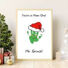 a christmas card with an image of a green handprint wearing a santa hat and the words you're a mean one