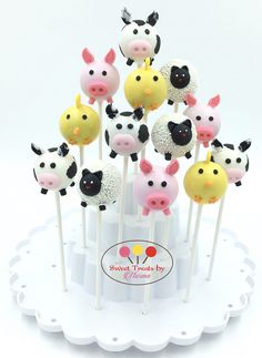 cake pops with farm animals on them sitting on a plate