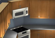 an overhead view of a kitchen with wood cabinets and white microwave above the stove top