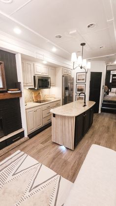 a large kitchen with white cabinets and wood flooring is pictured in this image from the living room