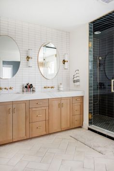 a bathroom with two sinks, mirrors and a walk - in shower next to it