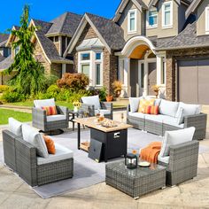 an outdoor living room with grey wicker furniture and orange pillows on the couches