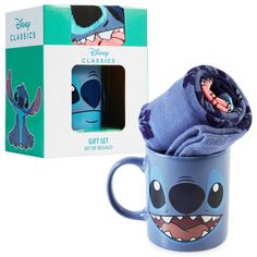 a coffee mug with a blanket wrapped around it in front of a boxed gift box