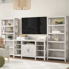 a living room with white bookcases and a flat screen tv on the wall