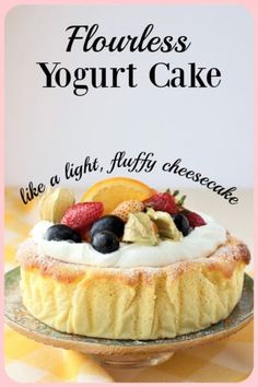 a cake with fruit on top and the words flourless yogurt cake above it