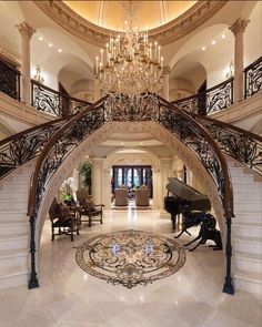 a grand piano is sitting in the middle of a large foyer with chandelier