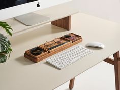 a computer desk with a keyboard, mouse and glasses sitting on it's tray