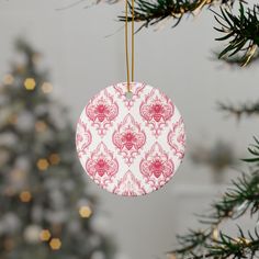 a pink and white ornament hanging from a christmas tree