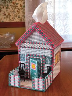 a tissue dispenser made to look like a house with a roof and windows