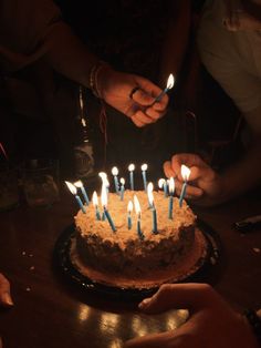 someone lighting candles on a birthday cake