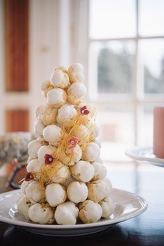 a white plate topped with marshmallows on top of a table next to a window