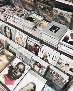 many magazines are stacked on top of each other