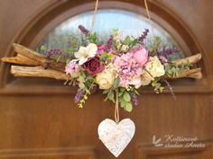 a heart hanging from a door with flowers on it