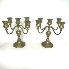 three brass candelabra candlesticks on a white background