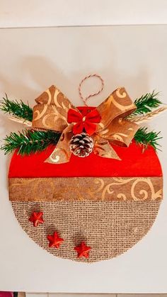 a christmas ornament hanging on the wall with red and gold decorations around it